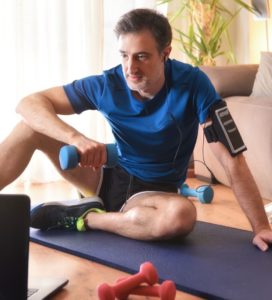 a man sitting on a couch holding a barbell