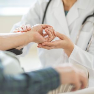 Doctor checking patient's hand pain