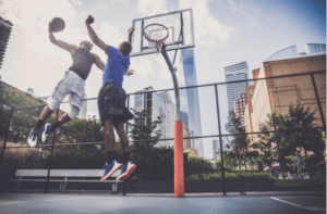 Two afroamerican athletes playing basketball outdoors