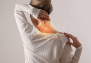 A woman suffering from back and neck pain