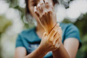 Woman holding her wrist in pain after spraining or possible fracturing it