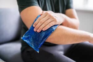 Man icing his elbow due to "tennis elbow" pain