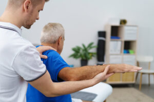 Physical therapist evaluating shoulder mobility in an older adult with possible rotator cuff injury.