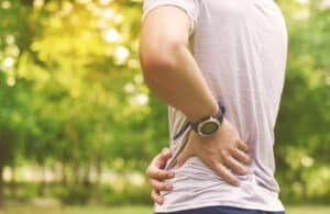 Person experiencing lower back pain that may require orthopedic evaluation.