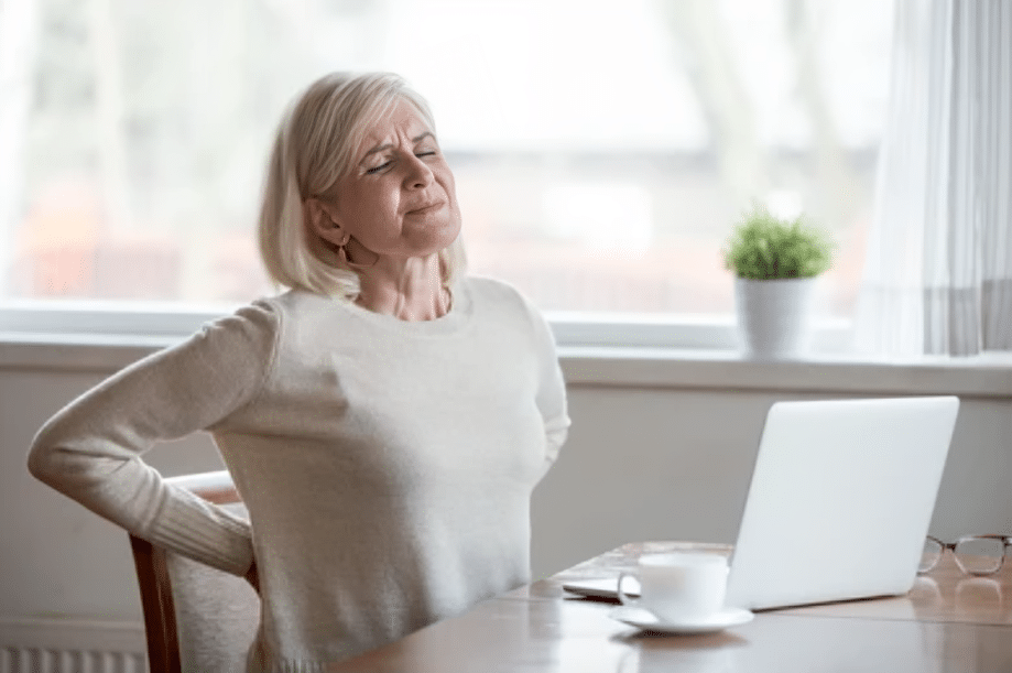 Woman experiencing lower back pain related to a possible herniated disc